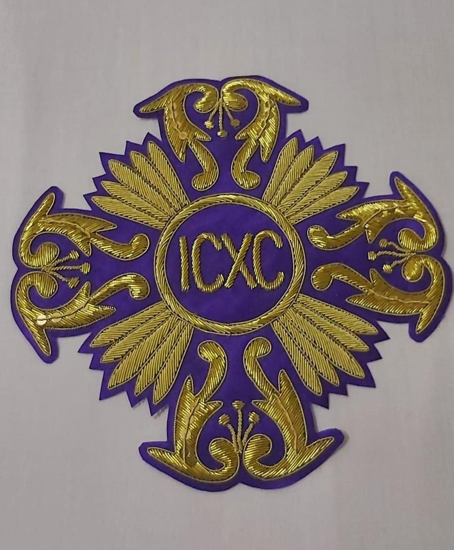 Purple vestment cross with lettered medallion and feather rays